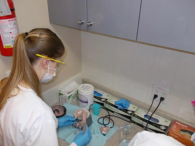 Female scientist in lab coat working at a lab bench with various equipment and materials.