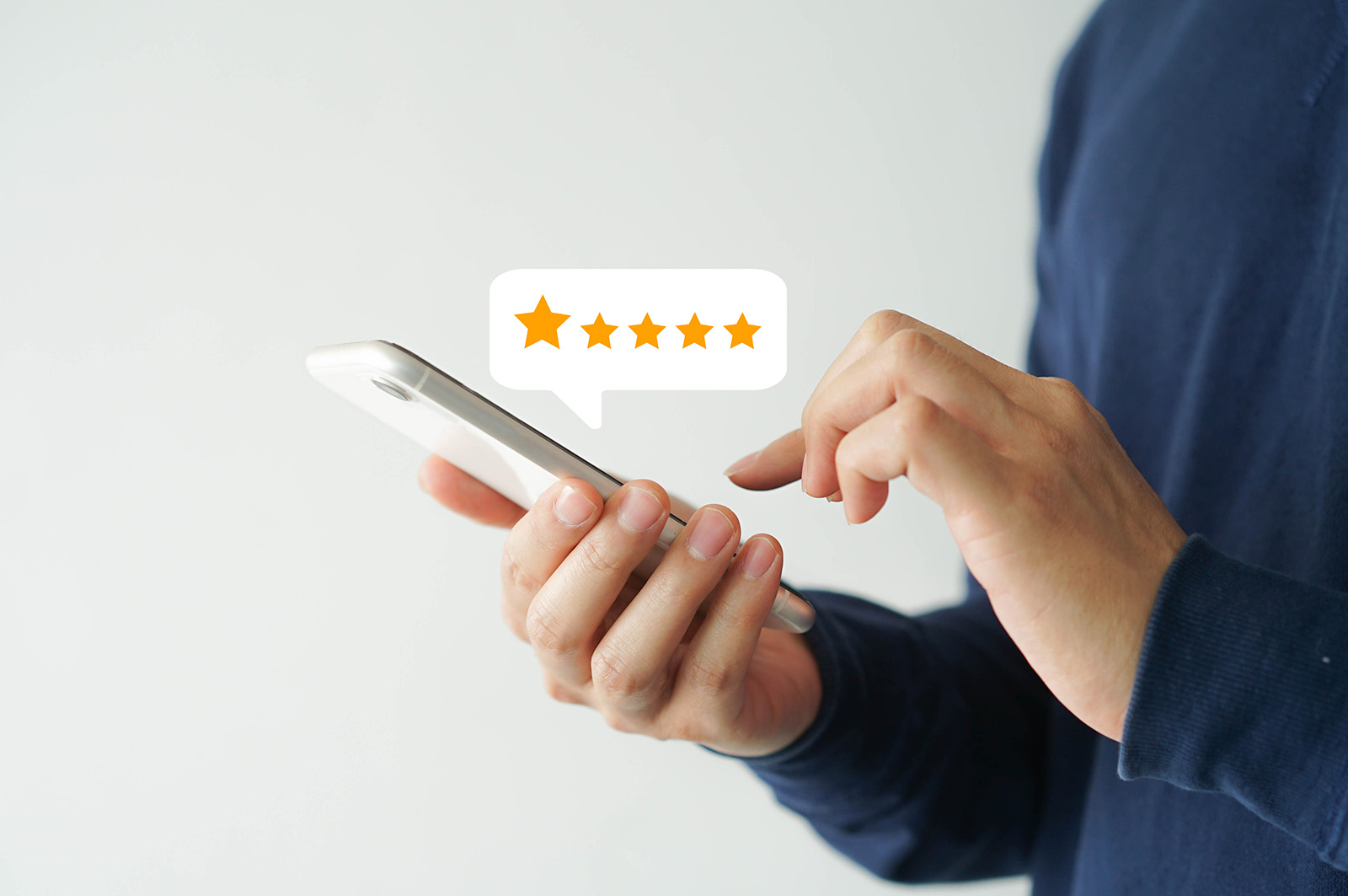 The image shows a person s hand holding a smartphone displaying a star rating graphic, suggesting an appraisal or customer feedback system.