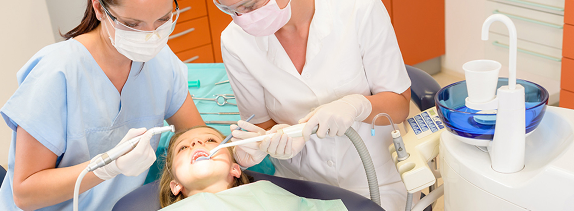 The image shows a dental professional performing oral care on a patient while wearing protective gear.